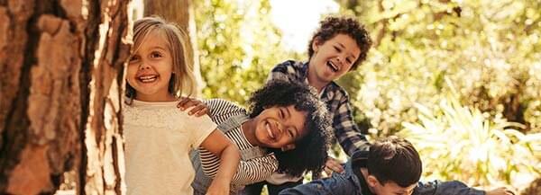 Fyra glada förskolebarn i skogen - Förskolans läroplan