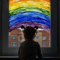 Ett ensamt litet barn framför ett fönster | © Nikolay Amoseev / Getty Images
