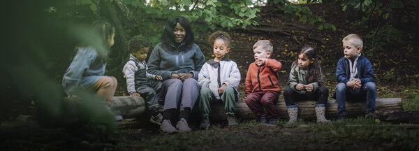 Pedagog utomhus med ett flertal förskolebarn | © Maskot / Getty Images