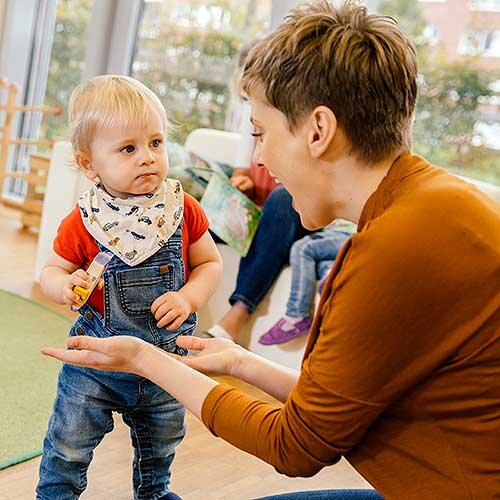 Litet förskolebarn leker med en pedagog | © Mareen Fischinger / Getty Images